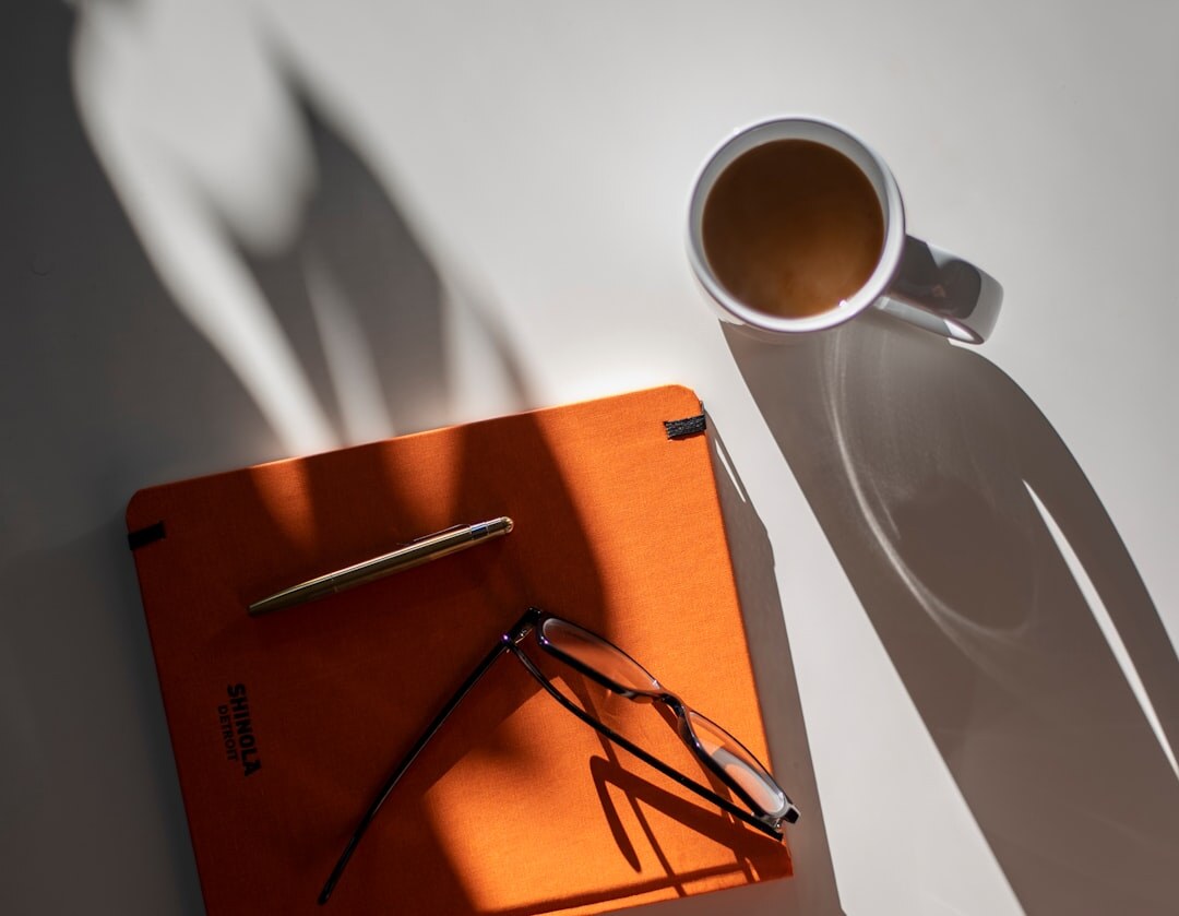 Detective notebook with pen, coffee cup and case photos